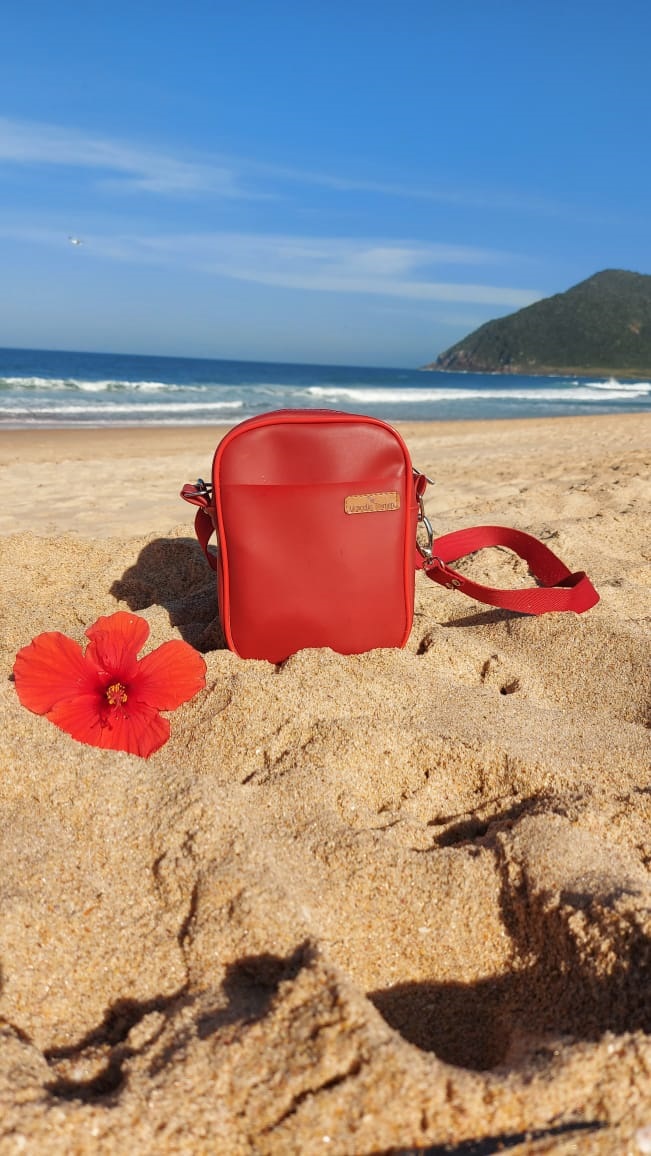 Bolsa vermelha com paisagem de mar ao fundo